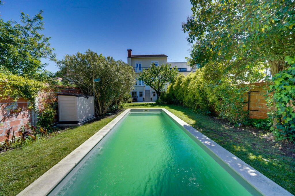Vue sur piscine jardin et façade de la maison